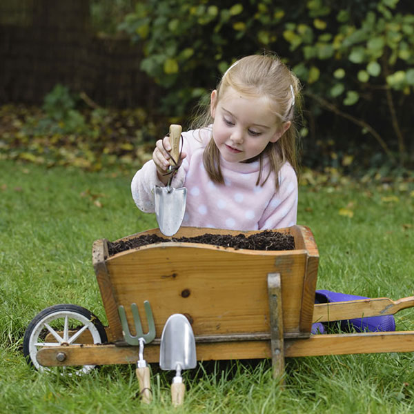 Barn med trädgårdsredskap i barnstorlek